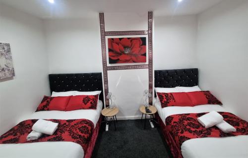 two beds in a room with red and white pillows at *A!S* Setup for your most amazing relaxed stay + Free Parking + Free Fast WiFi * in Headingley
