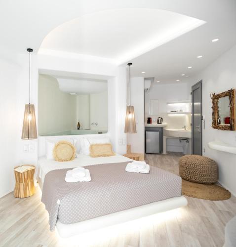 a white bedroom with a large bed with two towels at Majestique of Naxos in Naxos Chora