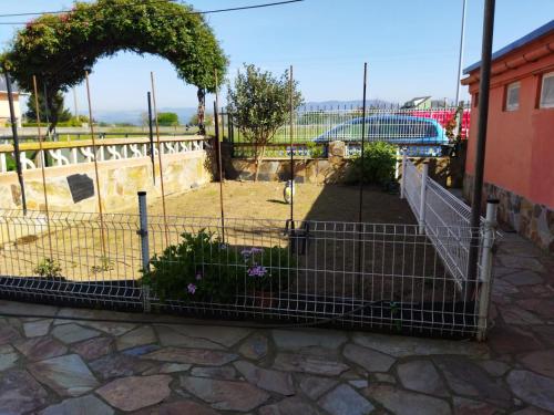 einen Zaun mit lila Blumen im Hof in der Unterkunft A Pedriña Ribadeo in Ribadeo