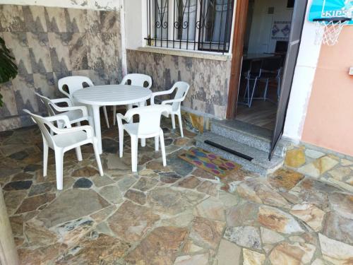 einen Tisch und Stühle vor einem Gebäude in der Unterkunft A Pedriña Ribadeo in Ribadeo