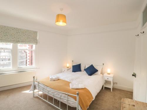 a bedroom with a bed and two windows at Bluebell Apartment in Swanage