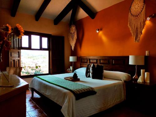1 dormitorio con 1 cama grande y pared de color naranja en Santuario Las Escaleras en San Cristóbal de Las Casas