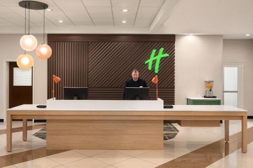 a man standing in front of a reception desk at Holiday Inn Florence by IHG in Florence