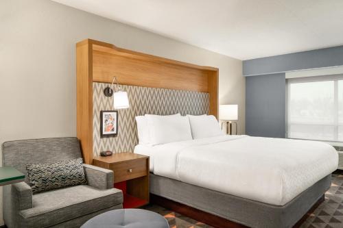 a hotel room with a bed and a chair at Holiday Inn Florence by IHG in Florence