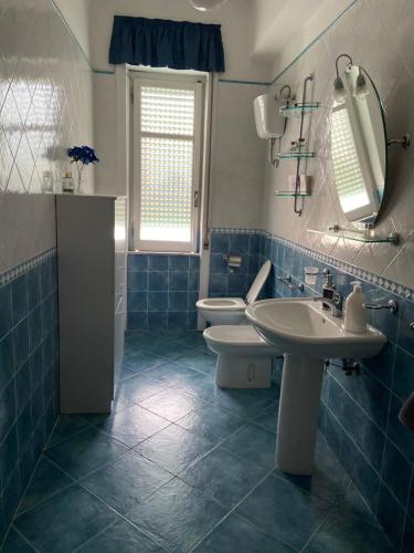 アグローポリにあるLe Cycasの青と白のバスルーム(洗面台2台、トイレ付)
