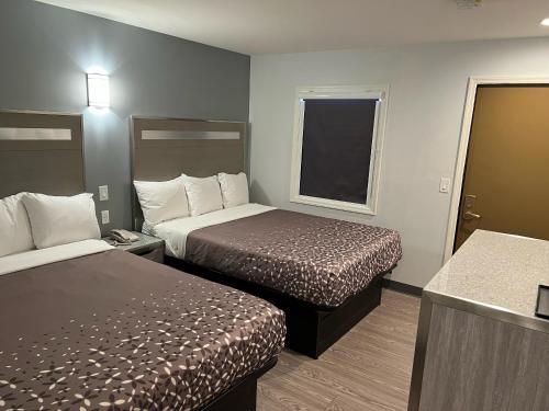 a hotel room with two beds and a window at 112 Motel in Medford
