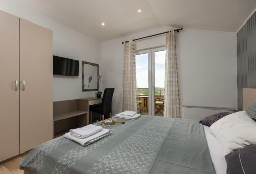 a bedroom with a bed and a desk and a window at B&B Villa Oasa 1 in Rovinj