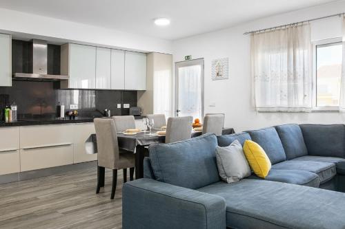 a living room and kitchen with a blue couch and a table at Just Sea in Peniche