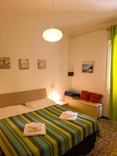 a bedroom with a bed with two towels on it at Classic Monterossino Apartment in Old Town in Monterosso al Mare