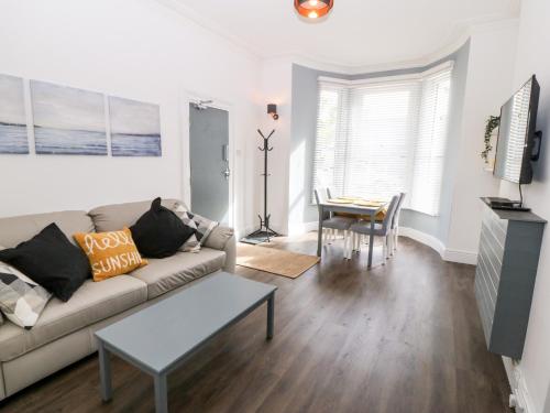 a living room with a couch and a table at Rothlea Flat 1 in Pwllheli