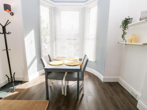 a dining room with a table and chairs at Rothlea Flat 1 in Pwllheli