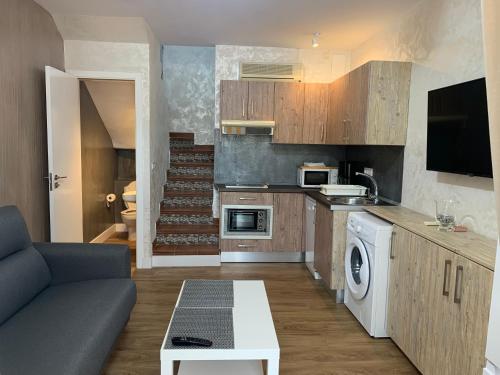 Una sala de estar con un sofá y una cocina. en Bungalow Green Oasis 1010, en Maspalomas