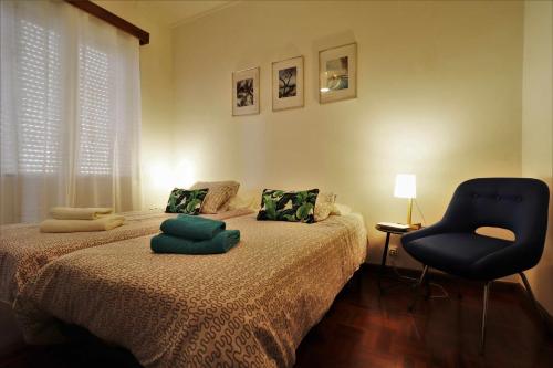 ein Schlafzimmer mit einem Bett und einem blauen Stuhl in der Unterkunft Costa Norte Guesthouse in Ribeira Grande