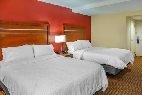 - 2 lits dans une chambre d'hôtel aux murs rouges dans l'établissement Holiday Inn Express Harrisburg SW - Mechanicsburg, an IHG Hotel, à Mechanicsburg