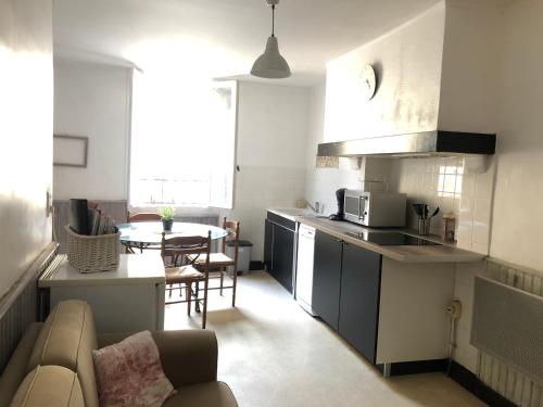 une cuisine et un salon avec un canapé et une table dans l'établissement Jolie maison de village à Roquecourbe, à Roquecourbe