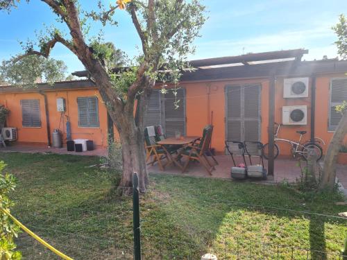 una casa naranja con una mesa y sillas en el patio en Ostia Antica Urlaub mal anders, en Ostia Antica