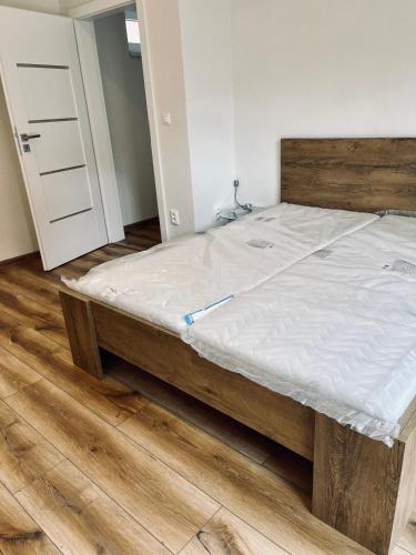 a bed with a wooden frame in a room at Luxus Resort - Zupko in Fiľakovo