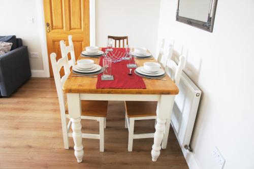 a dining room table with chairs and a red napkin at Brownstead Cottage in Navan