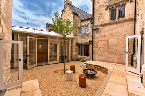 a courtyard with a tree in the middle of a building at Finest Retreats - ARC Painswick in Painswick