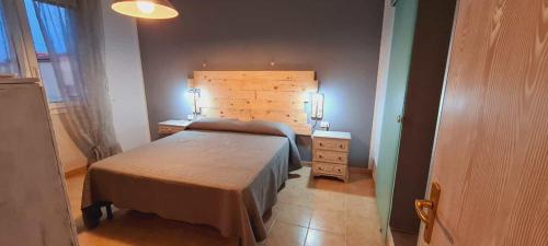 a bedroom with a bed with a wooden headboard at Relais La Terrazza in Palmadula