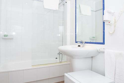 Hotel Cabo Festiñanza في سانكسينكسو: حمام أبيض مع حوض ومرآة