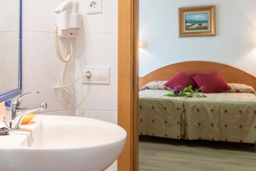 a bathroom with a sink and a bed at Hotel Cabo Festiñanza in Sanxenxo