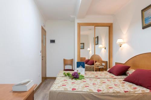 a bedroom with a large bed with flowers on it at Hotel Cabo Festiñanza in Sanxenxo