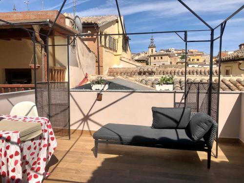a chair on a balcony with a view of a city at Apartamento Canónigo - terraza con vistas in Toledo