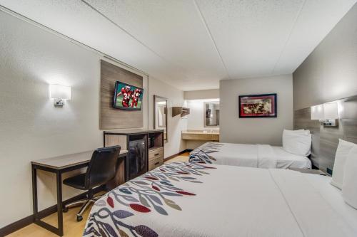 a hotel room with two beds and a desk at Red Roof Inn Columbia East - Ft Jackson in Columbia