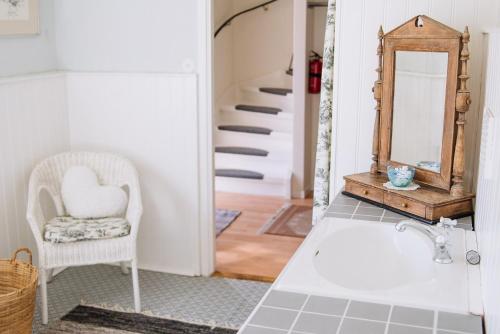 a bathroom with a mirror and a chair at Lust Huset in Ambjörnarp