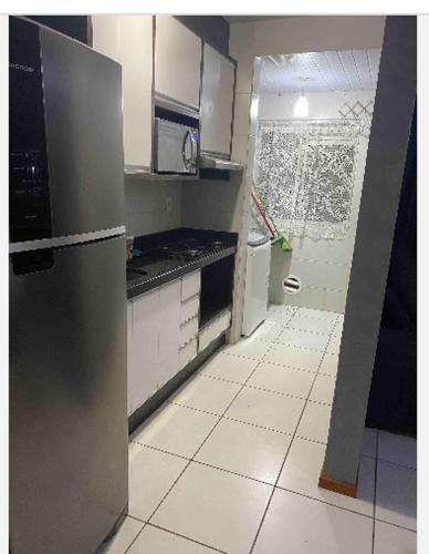 Apartamento completo في ريو دو سول: مطبخ مع ثلاجة وأرضية بلاط بيضاء