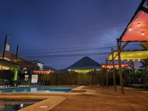 a swimming pool at night with a mountain in the background at San Bosco Inn in Fortuna