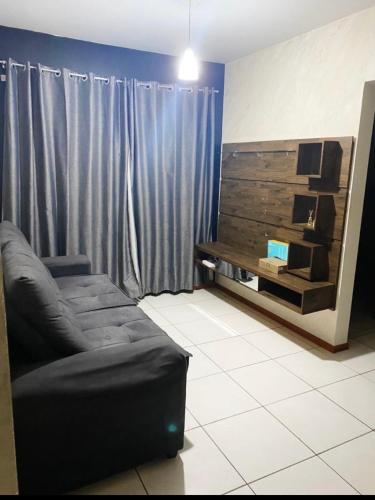 Apartamento completo في ريو دو سول: غرفة معيشة مع أريكة سوداء وطاولة