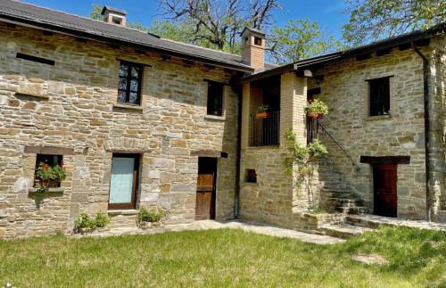 an old stone house with a grass yard at Agriturismo Il Noce d'Oro in Borgo Val di Taro