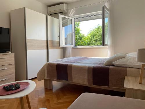 a bedroom with a large bed and a window at Apartment Beauty in Pula