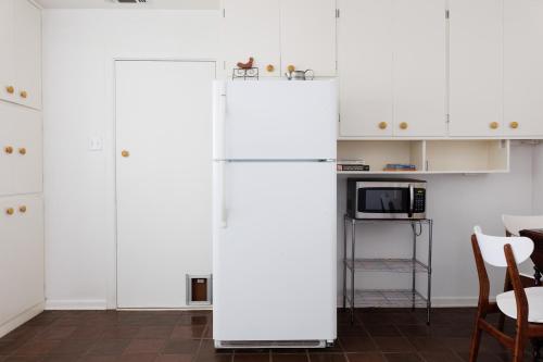 a white refrigerator in a kitchen with white cabinets at Beach House in Alpine in Alpine