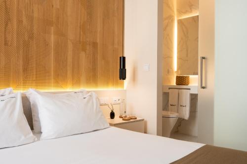 a white bed with white pillows in a bedroom at Tempo FLH Hotels Lisboa in Lisbon