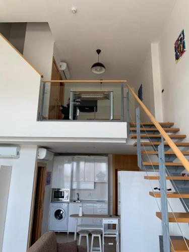 Pokój z klatką schodową i kuchnią ze stołem w obiekcie Loft luminoso Alcorcón M-40 Madrid w mieście Alcorcón
