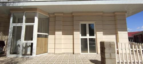 a building with glass doors on the side of it at Квартира в Радуга WEST in Koshkolʼ