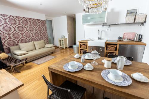 eine Küche und ein Wohnzimmer mit einem Holztisch und Stühlen in der Unterkunft Piran Holiday Apartments in the city center in Piran