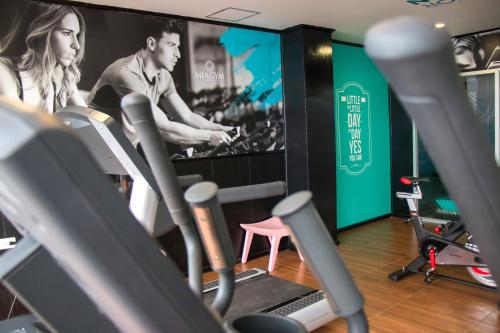 um ginásio com equipamento cardiovascular e um grande ecrã em Mia City Villahermosa em Villahermosa