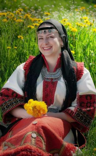 a woman is sitting in a field of flowers at вила Здравец in Yagodina