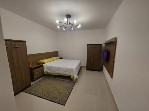 una piccola camera con letto e ventilatore a soffitto di Casa de Hóspedes em Parque Pinheiros - Sem Garagem a Taboão da Serra