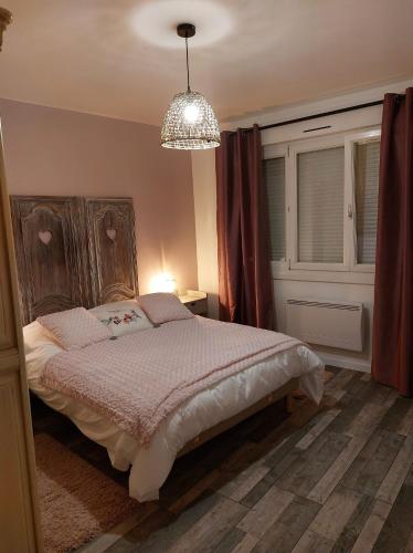Schlafzimmer mit einem Bett und einem Kronleuchter in der Unterkunft La Belle Vue Gîte Champenois B&B in Bergères-lès-Vertus