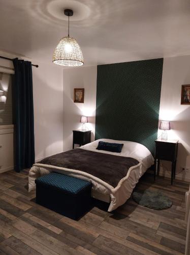- une chambre avec un lit, deux tables et un lustre dans l'établissement La Belle Vue Gîte Champenois B&B, à Bergères-lès-Vertus