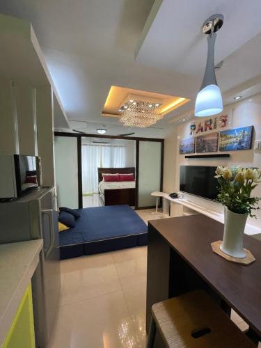 ein Wohnzimmer mit einem blauen Sofa in einem Zimmer in der Unterkunft Honey's Elysees Condotel - Davao in Davao City