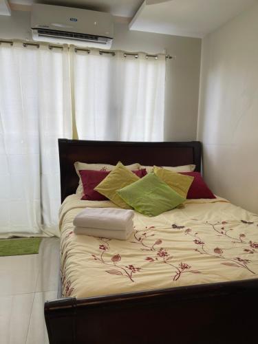 a bedroom with a large bed with flowers on it at Honey's Elysees Condotel - Davao in Davao City