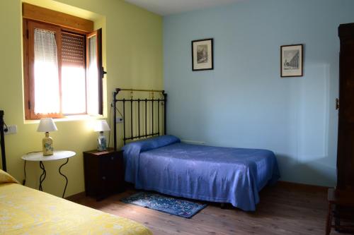 a bedroom with a bed and a window and a table at La Cantina de Daniel in Chatún