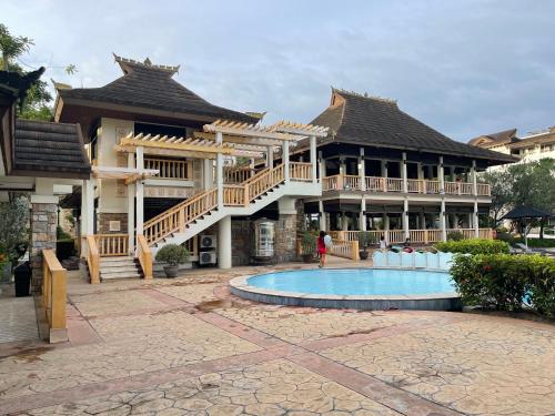 a large building with a swimming pool in front of it at Honey's Elysees Condotel - Davao in Davao City