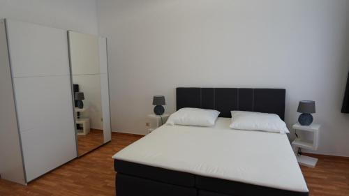 1 dormitorio con 1 cama blanca grande y espejo en Uta von Ballenstedt, en Ballenstedt